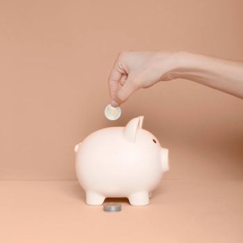 Building Wealth & Financial Security for a Strong Future Financial security - a hand inserting a coin into a pink piggy bank, symbolizing investment growth, retirement planning, and income protection.